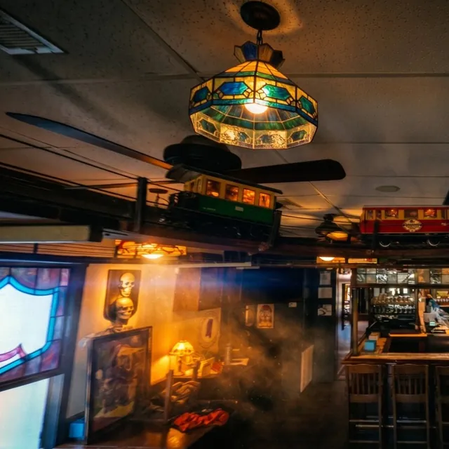 A Tiffany pendant lamp, with a model train running overhead