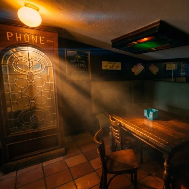 The nook by the leaded-glass door marked PHONE