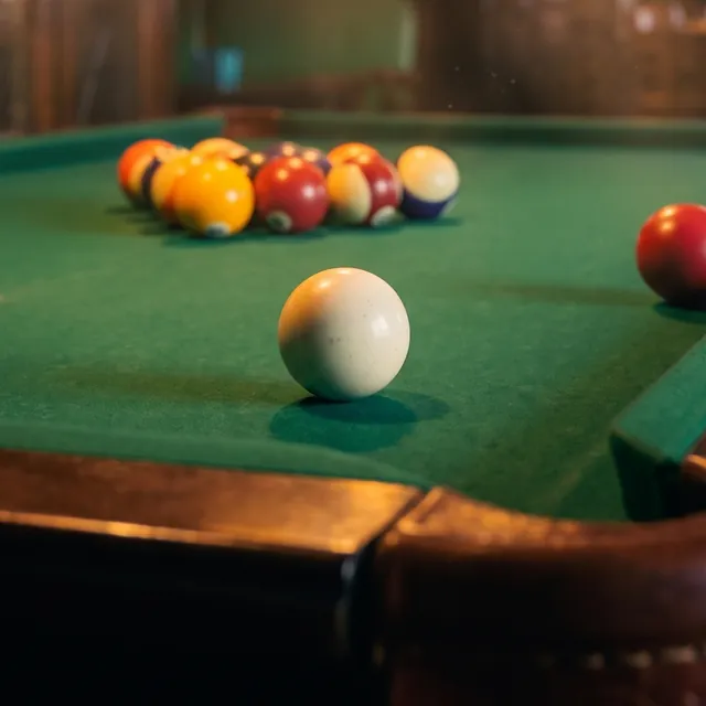 A pool game in progress on green felt